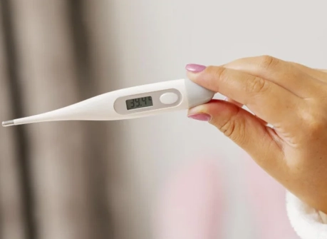 женщина держит градусник в руке