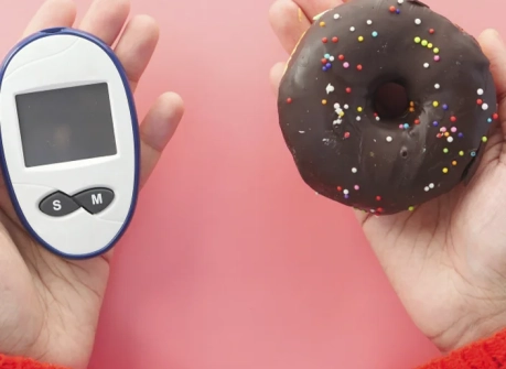 глюкометр и пончик в руках