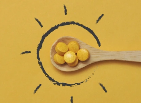 ложка с жёлтыми таблетками витамина D