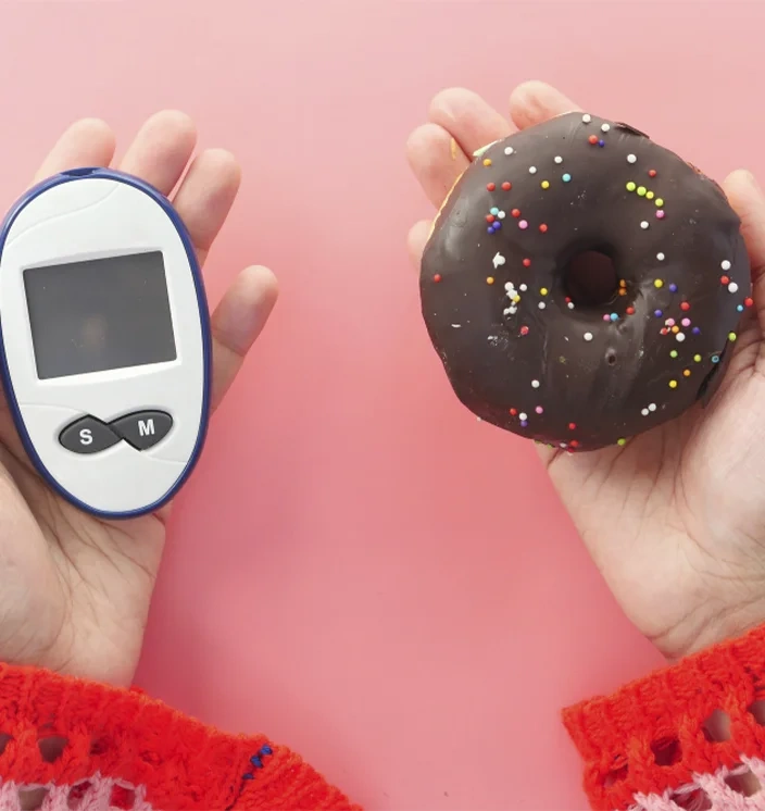 глюкометр и пончик в руках