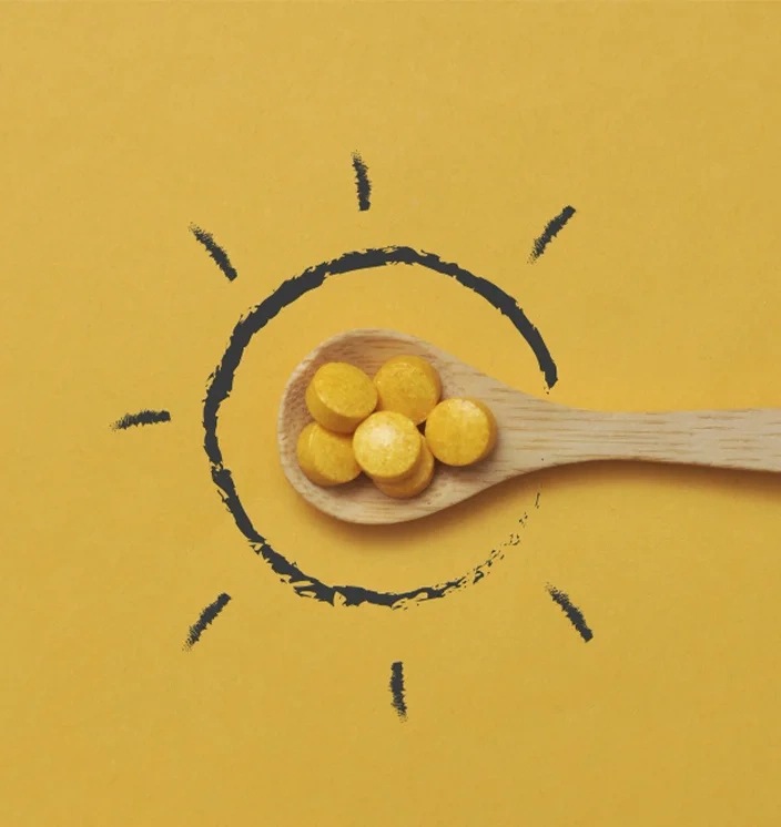 ложка с жёлтыми таблетками витамина D