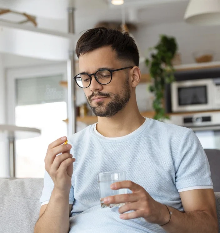 мужчина принимает капсулу витамина D