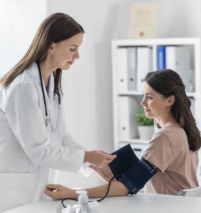 врач измеряет артериальное давление женщине