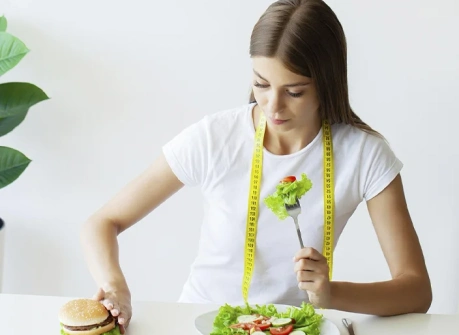 девушка выбирает здоровый салат вместо бургера