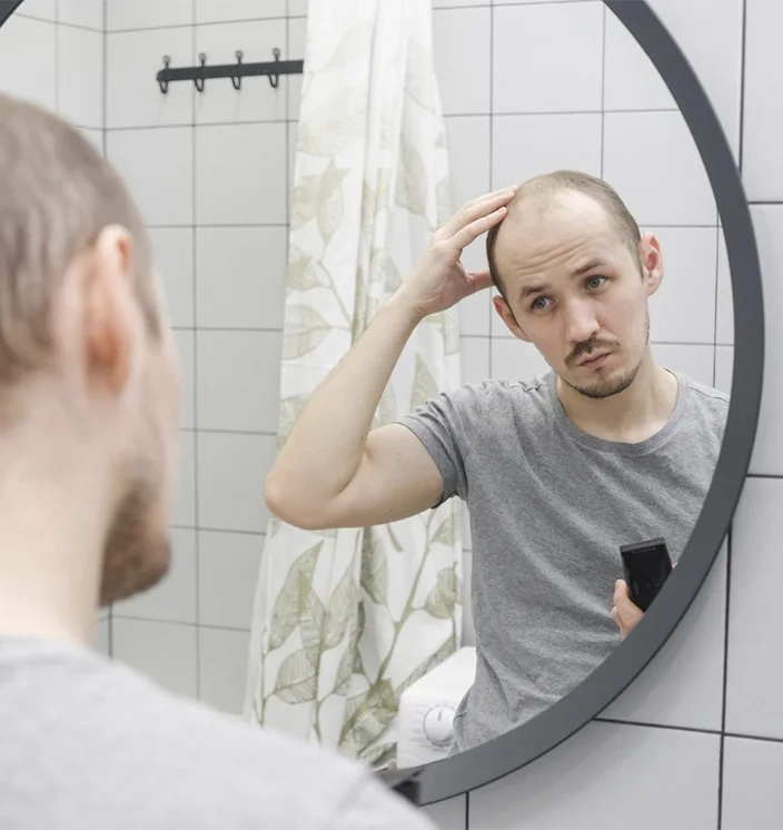 мужчина страдает сильным выпадением волос